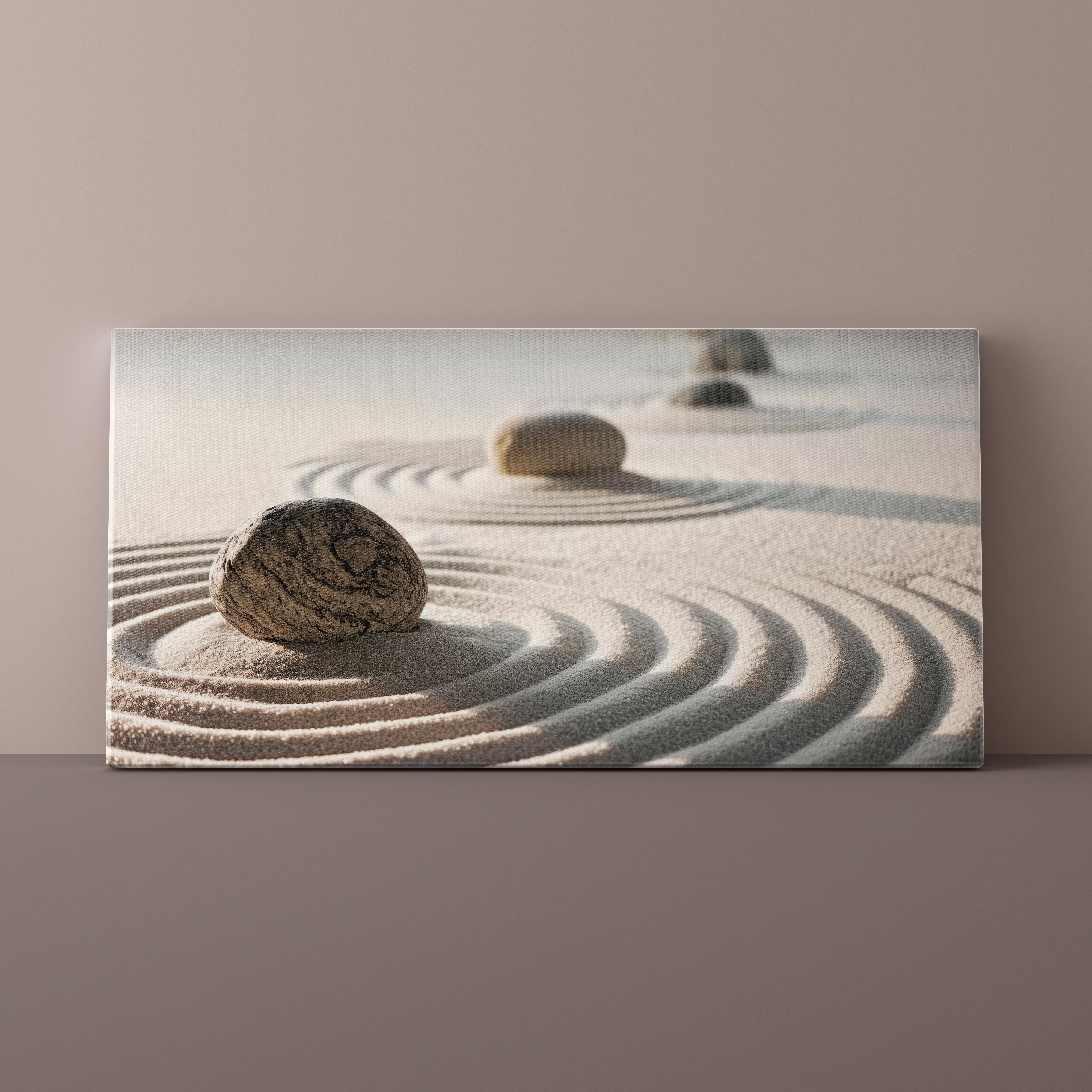 Canvas print of a rock in sand with concentric circles on a beige wall.
