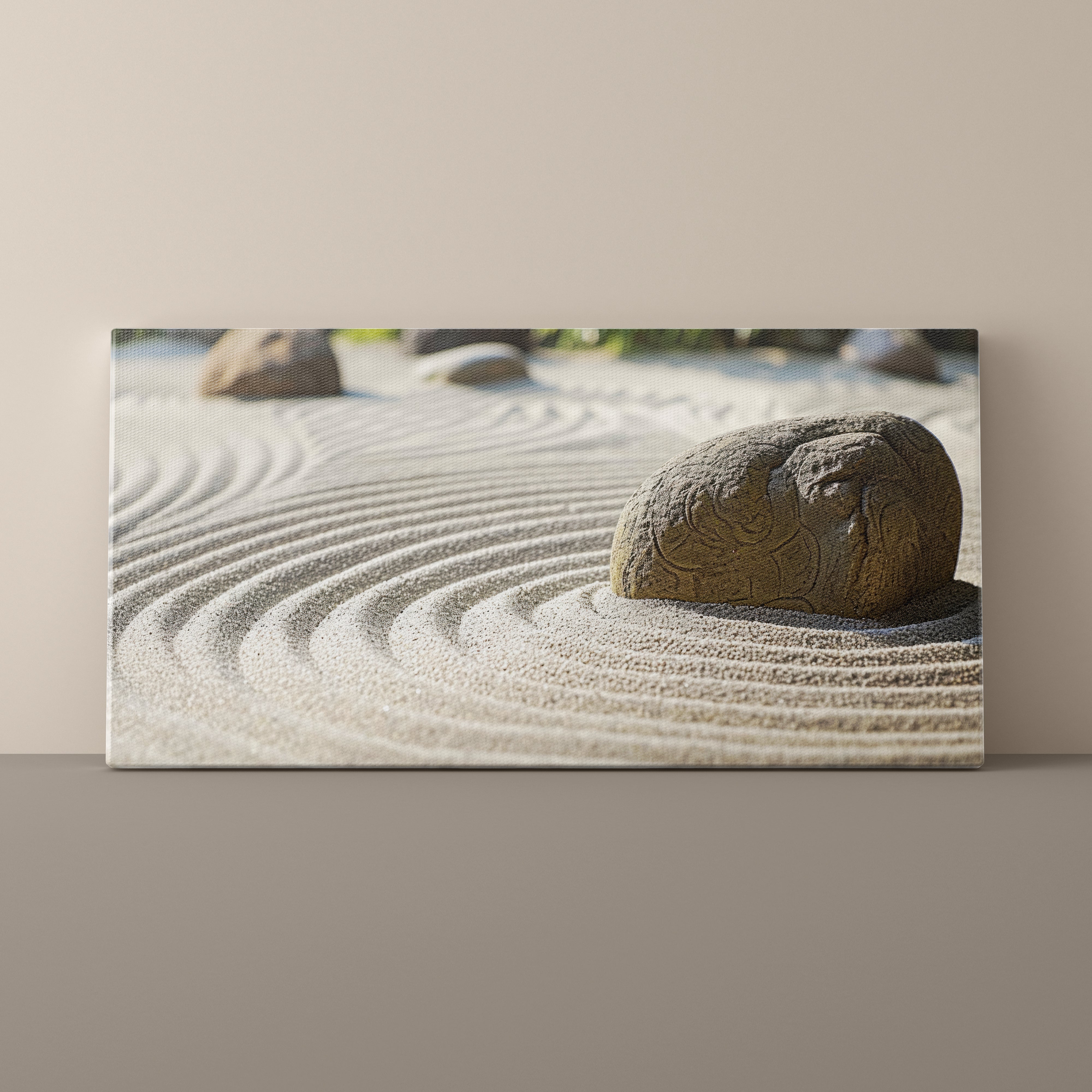 Canvas print of a rock in sand with raked lines on a beige wall.