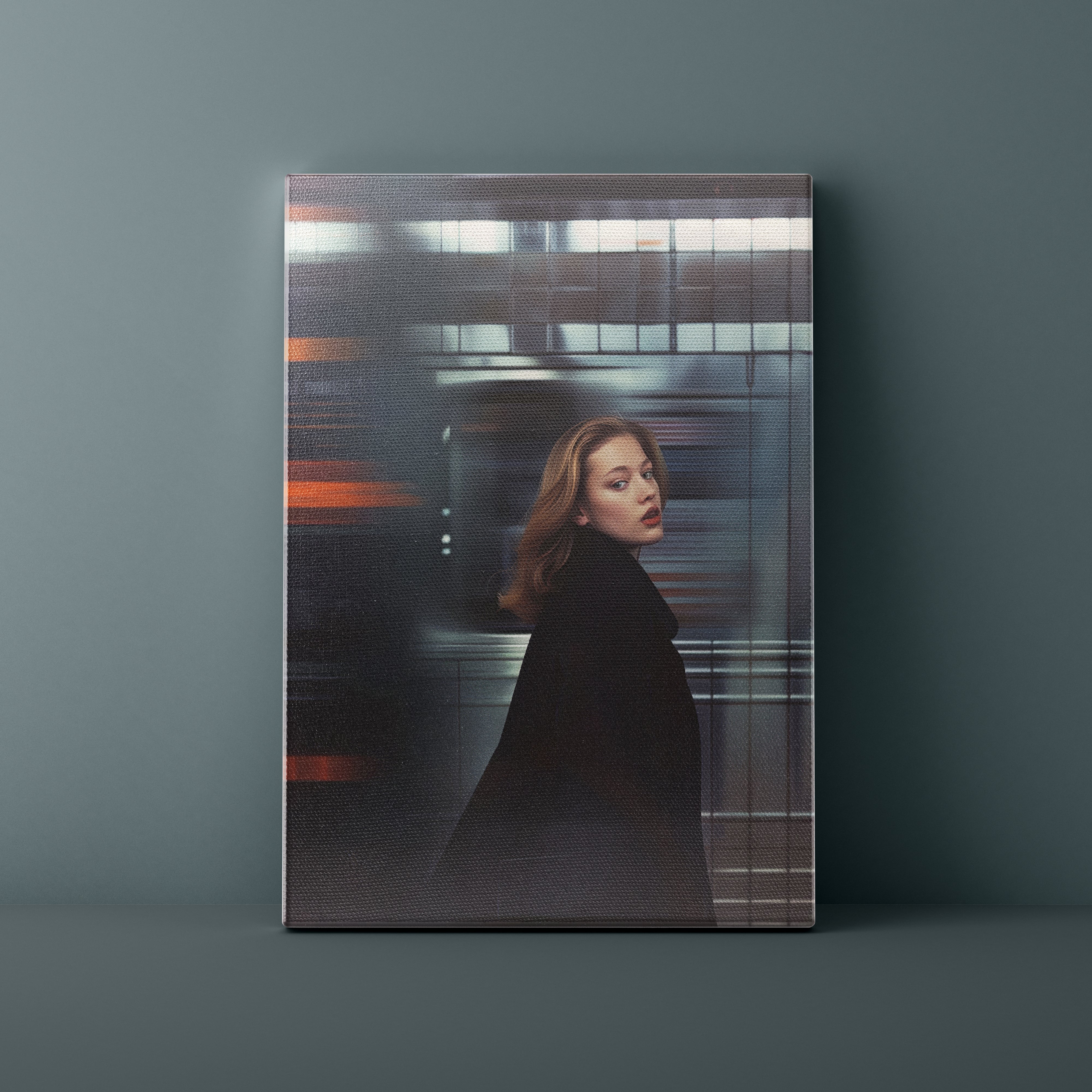 Canvas print of a woman in a black coat against a blurred train background