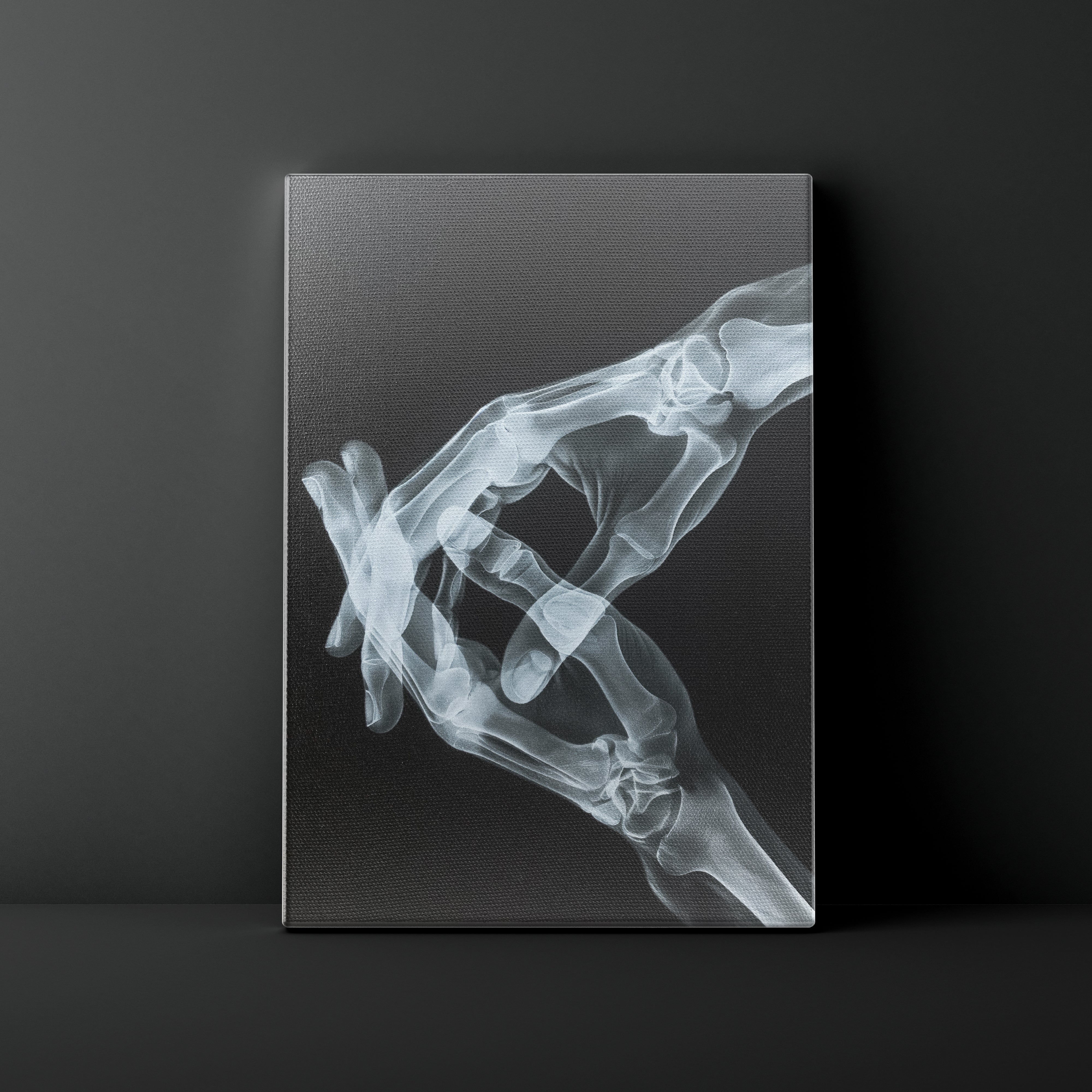 X-ray of a hand holding fingers against a dark background