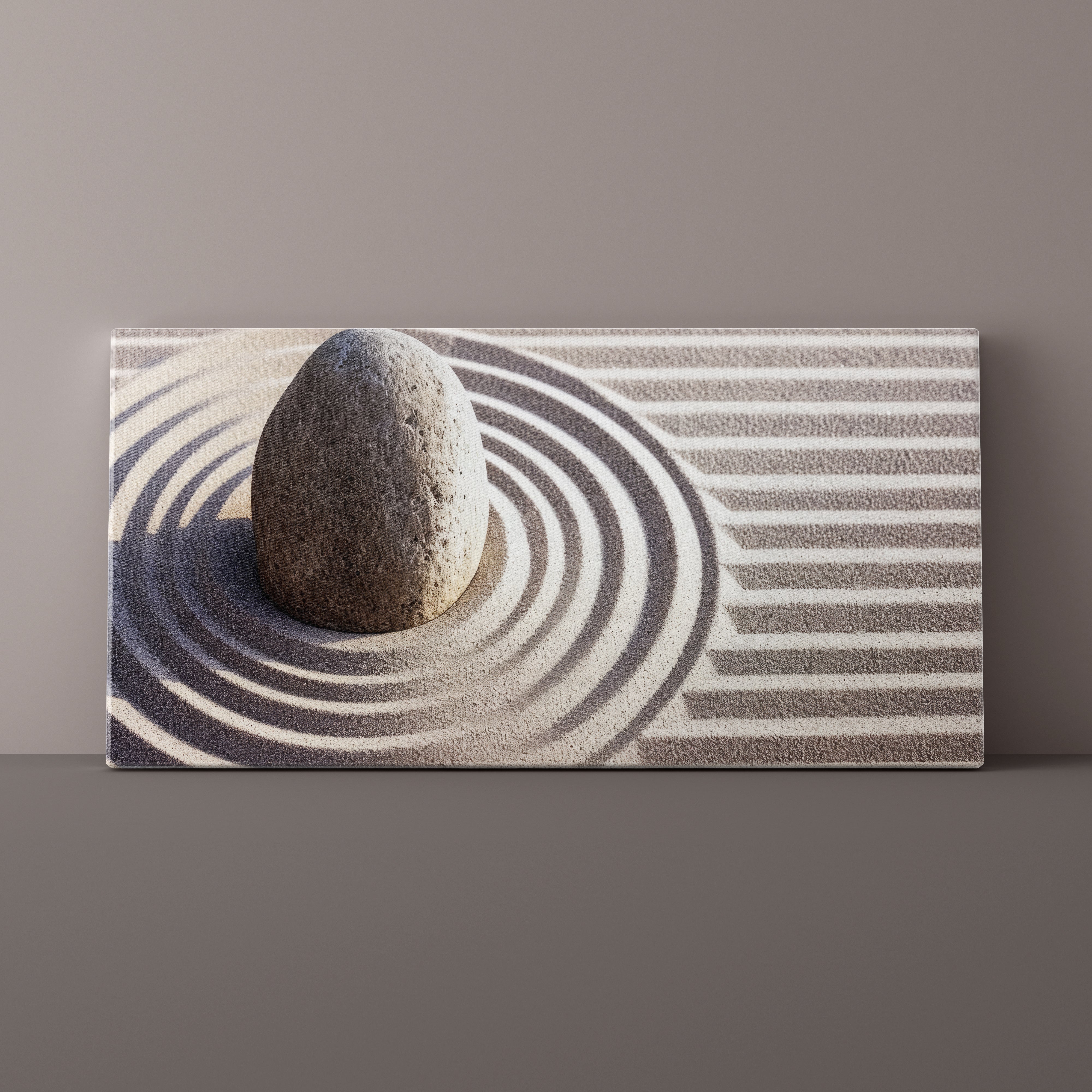Canvas print of a stone in sand with concentric circles on a gray background
