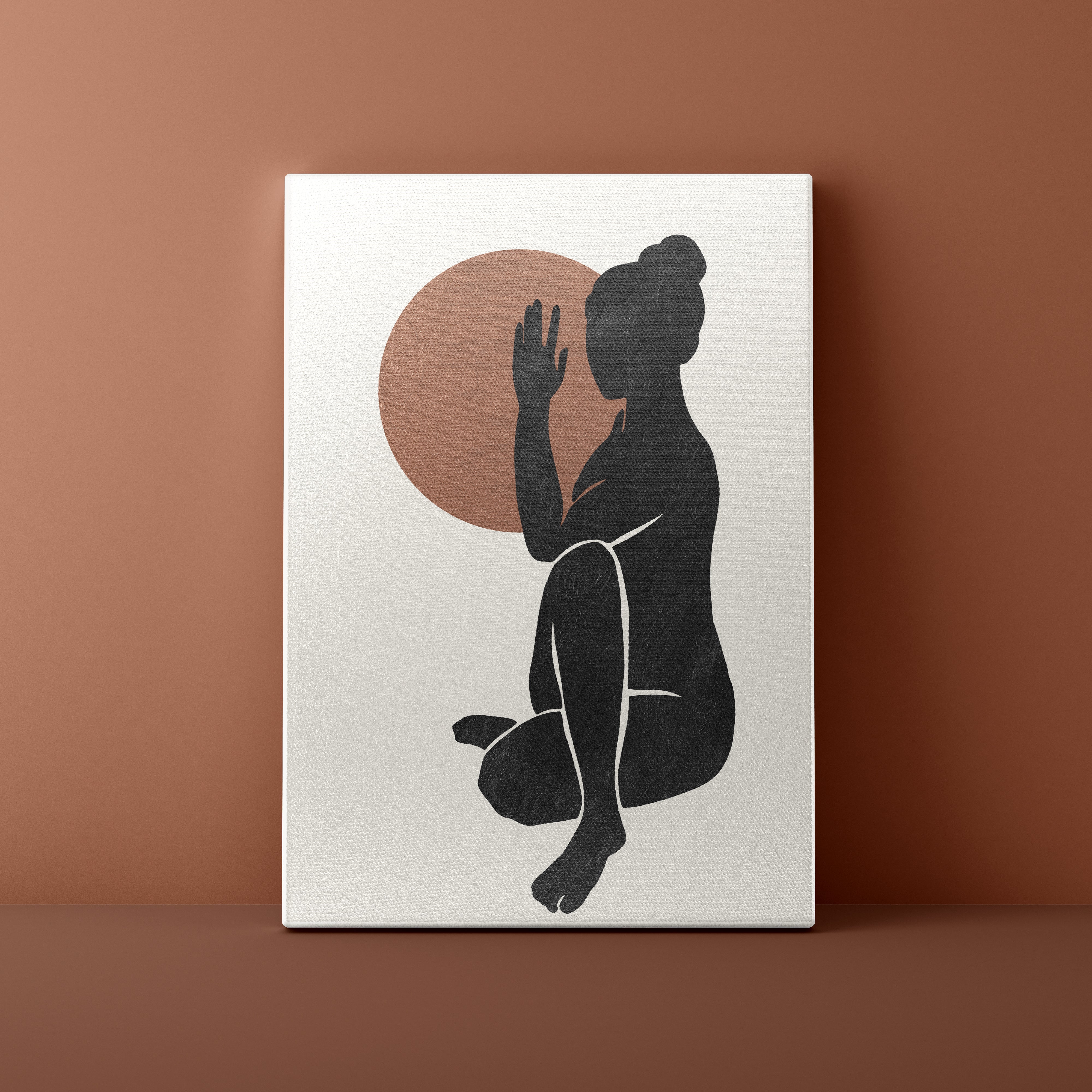 Canvas print with a black silhouette of a person against a brown circle on a beige background, leaning against a brown wall.