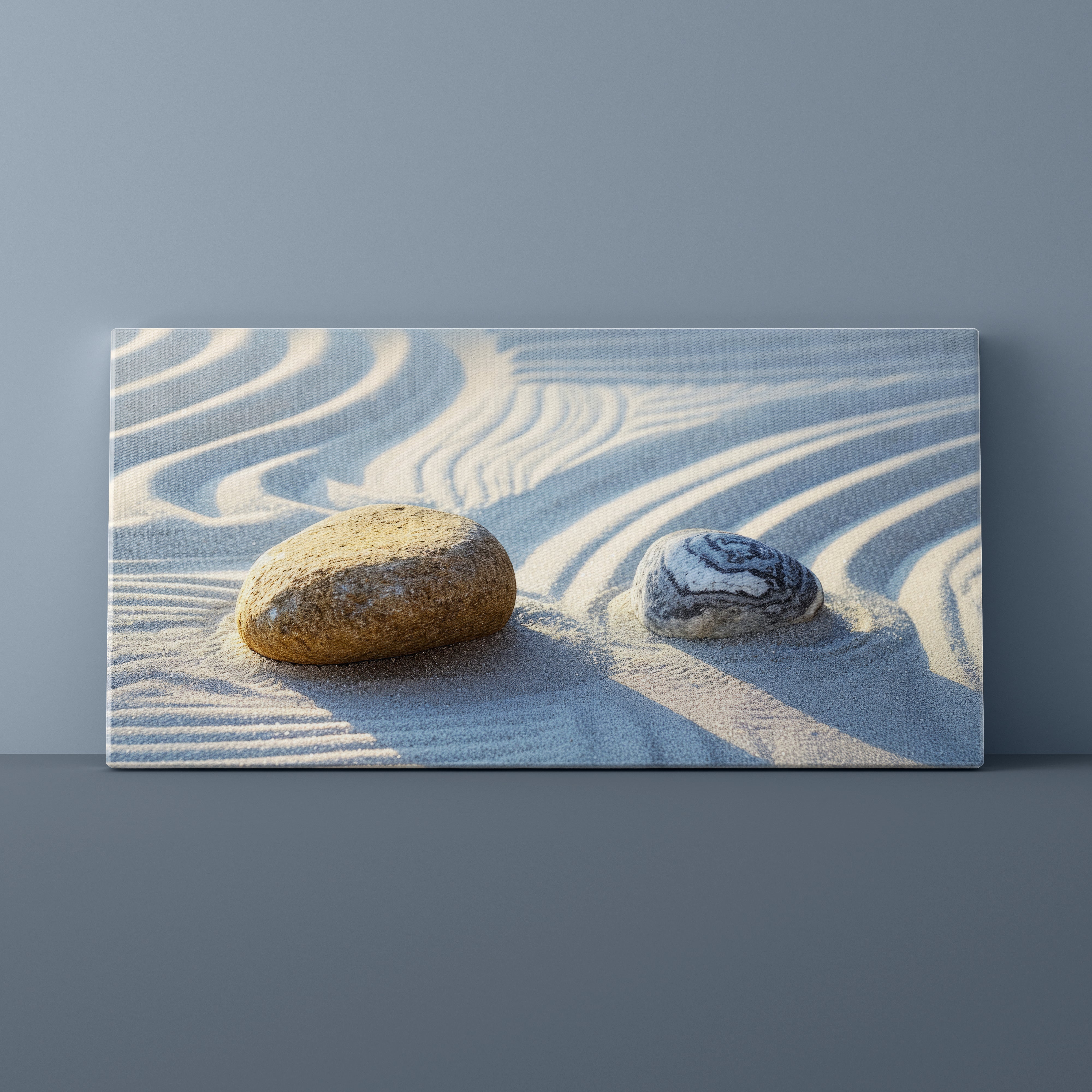 Two stones on sand with wavy lines against a gray background