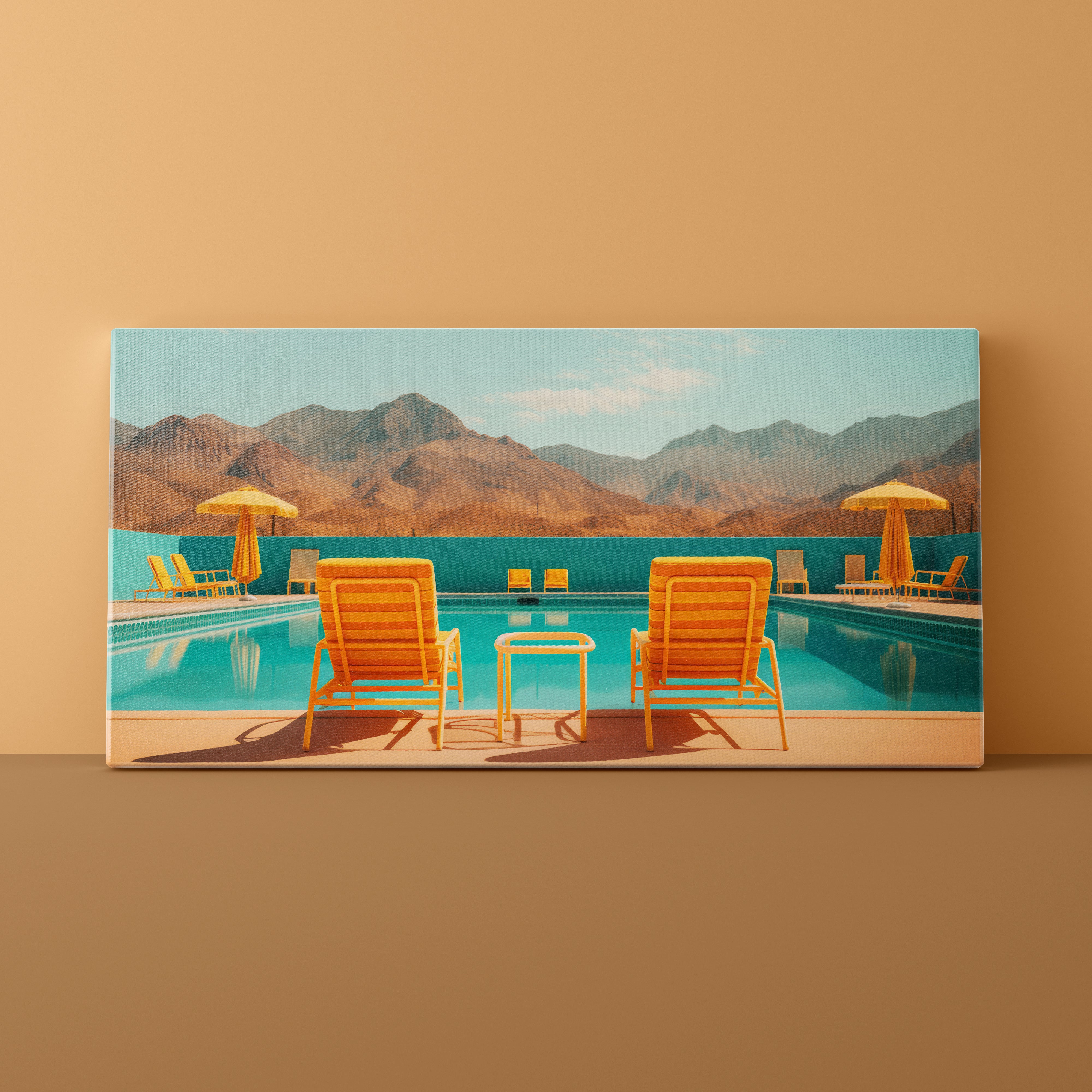 Canvas print of a pool scene with chairs and umbrellas against a mountain backdrop on a beige wall.