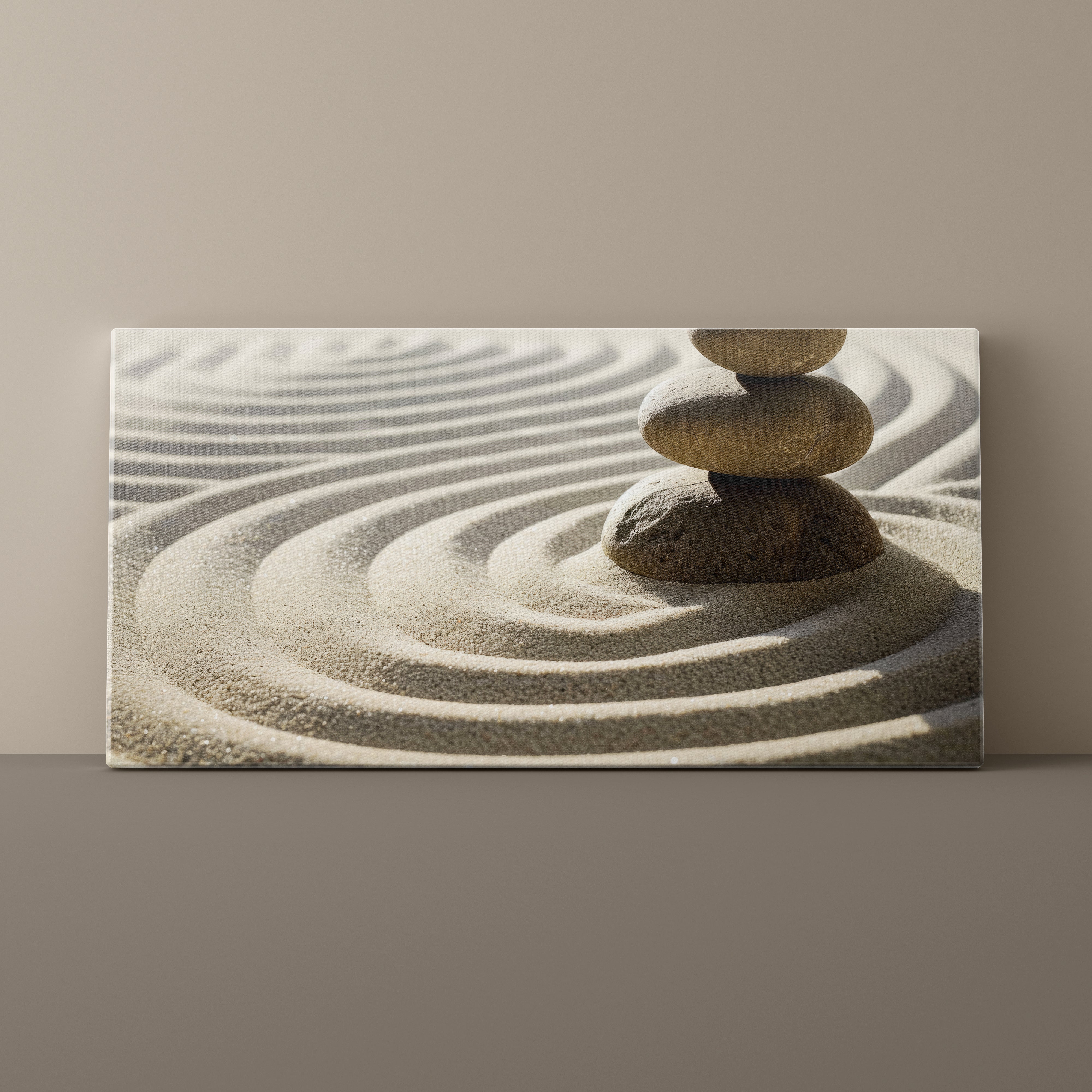 Canvas print of stacked stones in sand with concentric circles on a beige wall.